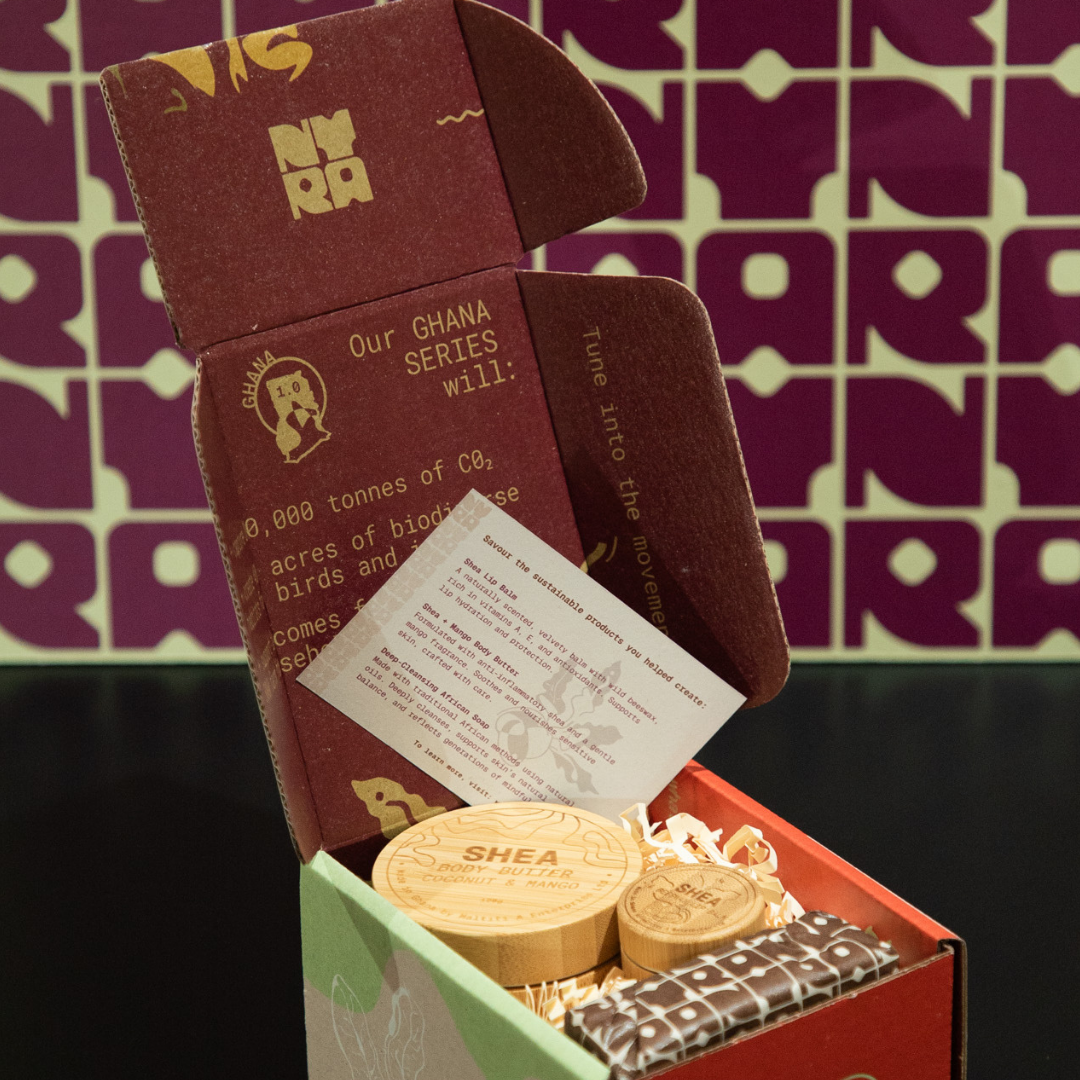 cardboard shea butter products in a box with a branded background